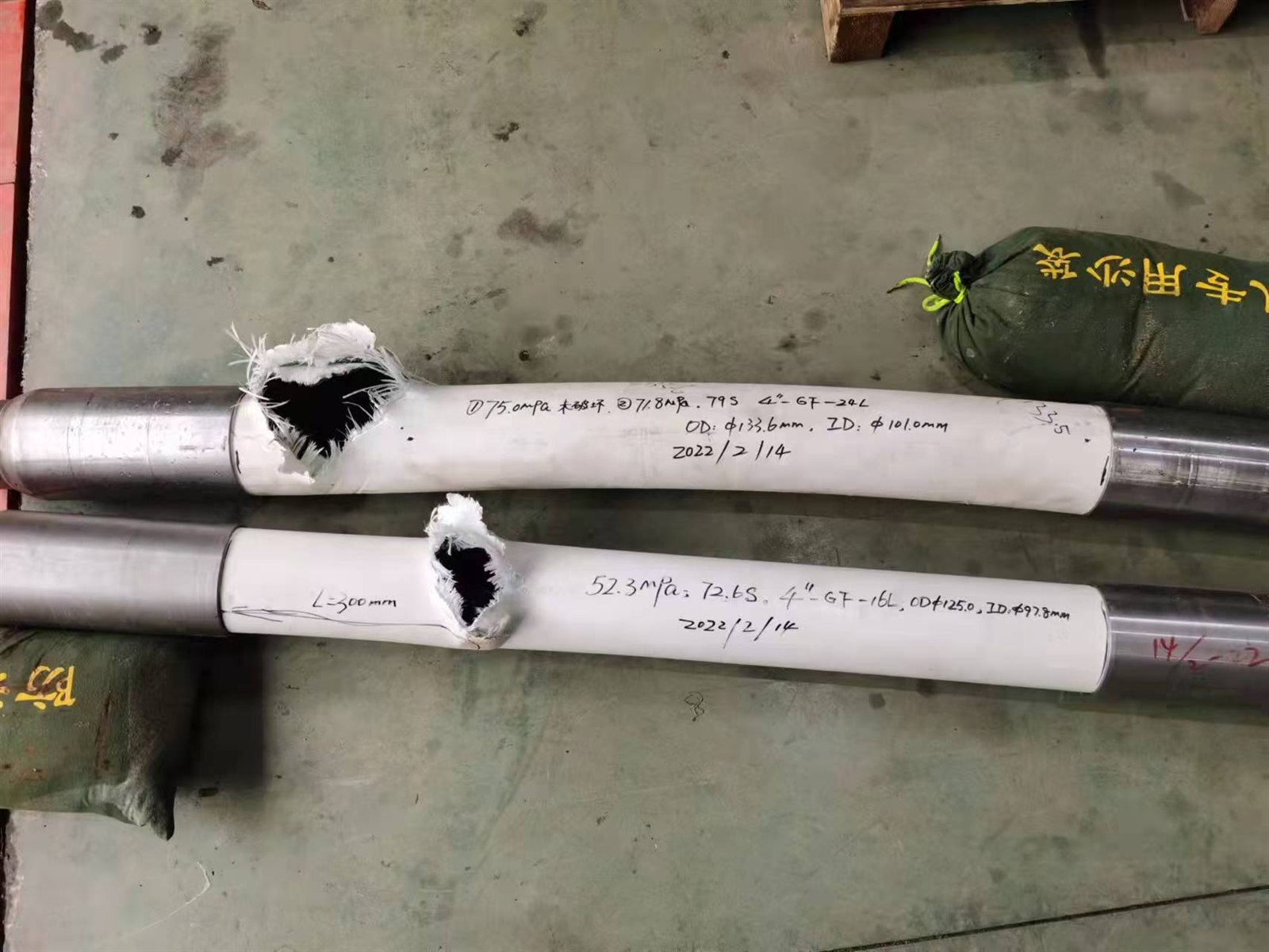 Two RTP pipe burst specimens with handwritten pressure, time and dimension data