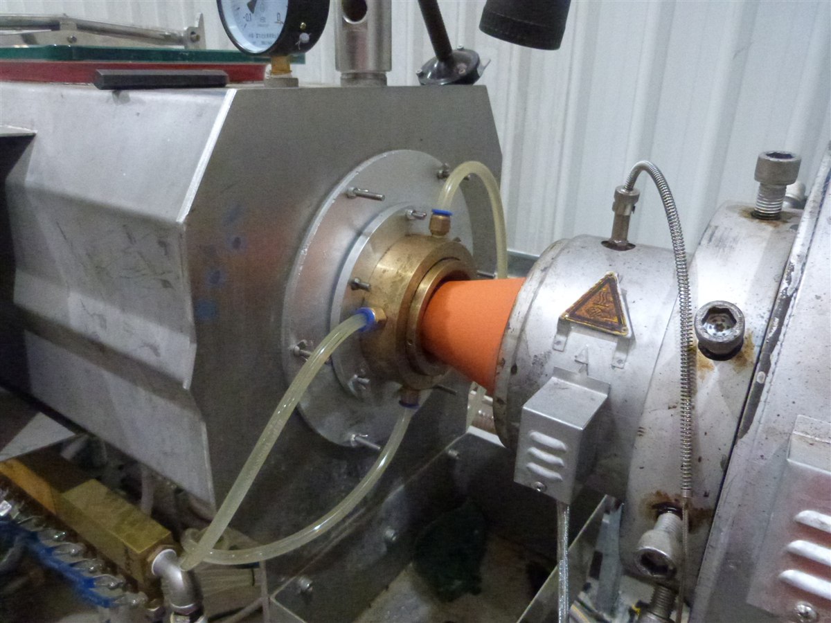 Polyethylene pipe leaving the die head of an extruder